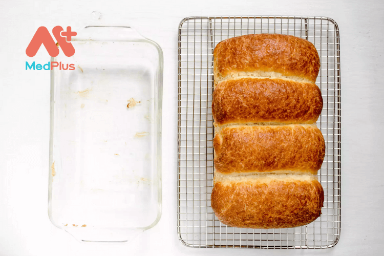 Nhấc bánh mì sữa Nhật Bản khỏi khuôn và để nguội trên giá nướng