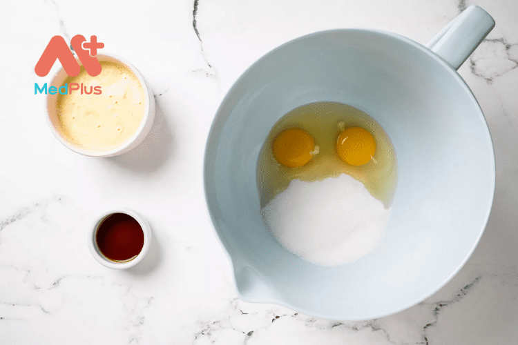 Cho vào bát trứng, đường, bơ tan chảy và vani